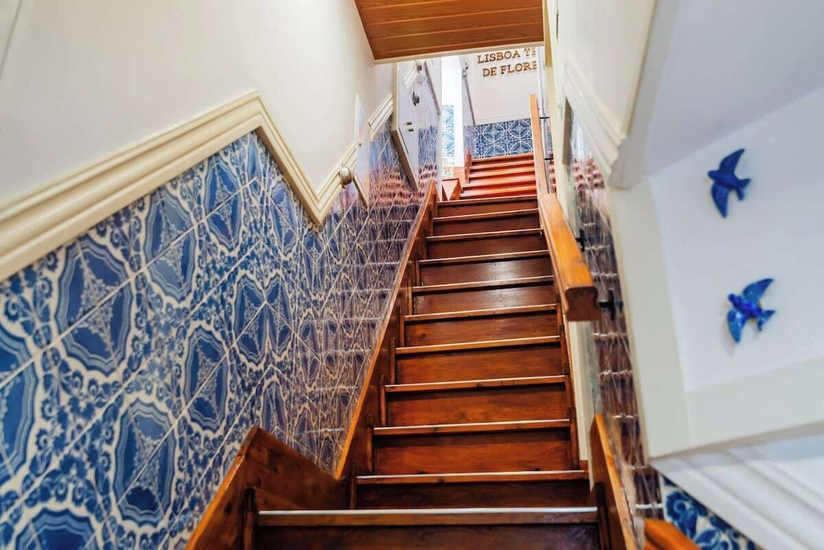 Un escalier avec des murs aux motifs bleus et des marches en bois.