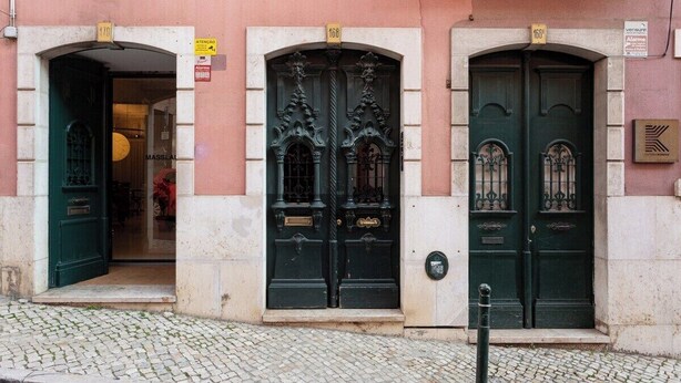Un bâtiment avec trois portes noires, chacune étant surmontée d’un numéro.