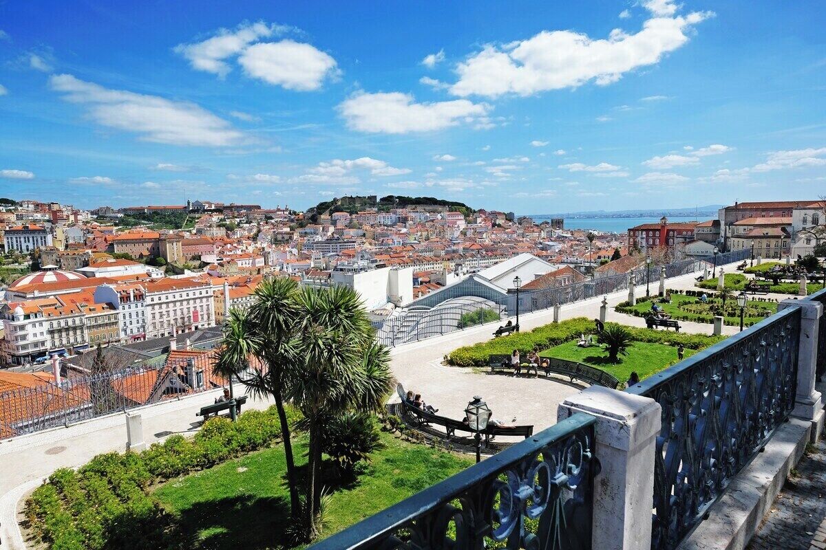 A cityscape with historic buildings, a prominent white structure, and a park area.