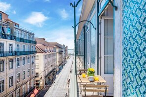 Ein Balkon mit Tisch, Stühlen und einem Blumenstrauß.