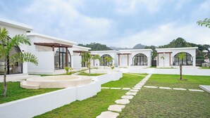 A modern resort with white buildings, a central courtyard, and a stone pathway. - Lazura Serenite (Kintamani)