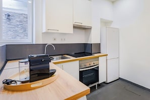 Eine moderne Küche mit Backofen, Kühlschrank und Fenster mit Meerblick.
