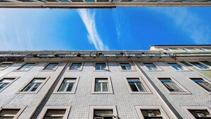 A multi-story building with a patterned facade, multiple windows, and a clear blue sky above. - Douradores Downtown Flat (Lisbon)