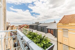 Ein Balkon mit Blick auf eine Stadtlandschaft, einschließlich Gebäude und ein weiter See.