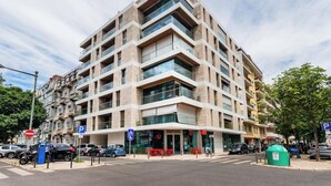 Un immeuble à plusieurs étages, doté d’une architecture moderne, de balcons et de grandes fenêtres.