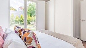 Een slaapkamer met een bed, een raam en een deur.