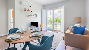 Een moderne woonkamer met een eethoek, een bank en een televisie.