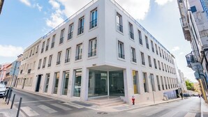 Un edificio moderno con un ingresso d'angolo, ampie finestre e una facciata piatta.