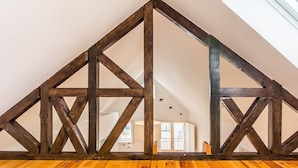 A room with a sloped ceiling, wooden beams, and a wooden floor. - Bright Alfama Loft with Mezzanine | Guest Inn (Lisbon)