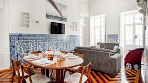 A dining area with a round table, chairs, and a blue and white tiled backsplash. - Downtown Chiado Treasure (Lisbon)