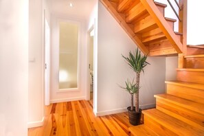 Eine Holztreppe mit einem Blumentopf daneben.