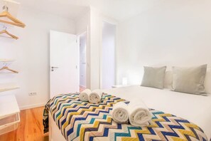 Ein Hotelzimmer mit Bett, Tür, Kleiderschrank und Spiegel.