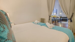 Una habitación de hotel con cama, escritorio y vistas a través de una ventana.