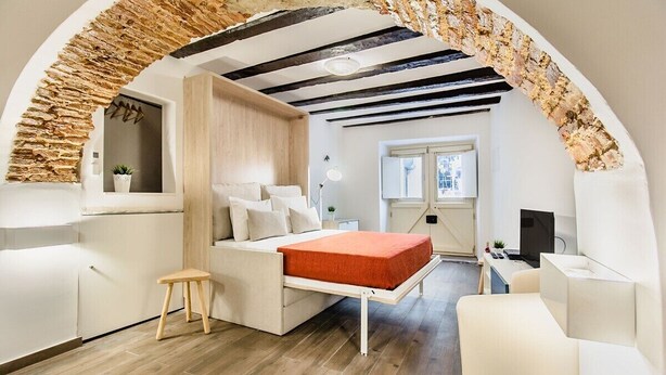 Ein modernes Interieur mit einem Bett, einem Schreibtisch und einem Fenster.