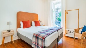 A bedroom with a bed, bedside tables, a window with a view, and a chair. - Conde 3BDR Luxury with Balcony (Lisbon)