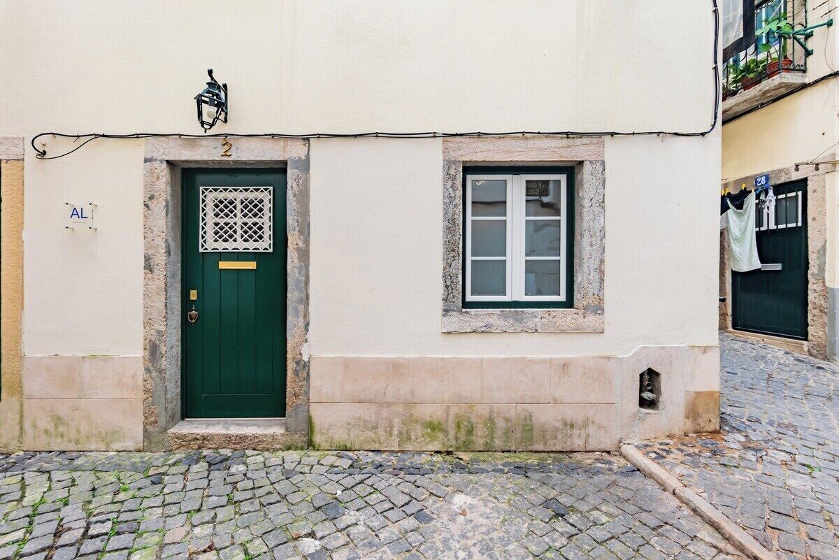 A building with a green door, a small window, and a number '2' above the door.