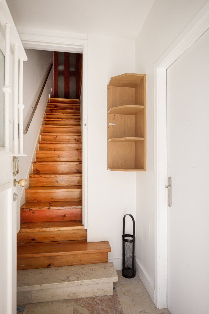 A staircase with wooden steps and a white wall.