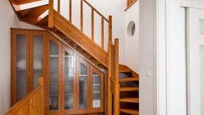 A wooden staircase with a glass door leading to a room with a white wall and a circular window. - Yellow Suites Duplex @ Cascais Historical Center (Cascais)