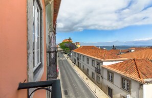 Straßenansicht mit Gebäuden, blauem Himmel und weiter Meerblick.