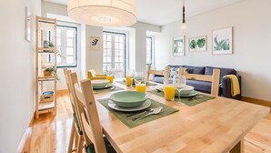 Un comedor con una mesa de madera, sillas y una lámpara colgante.
