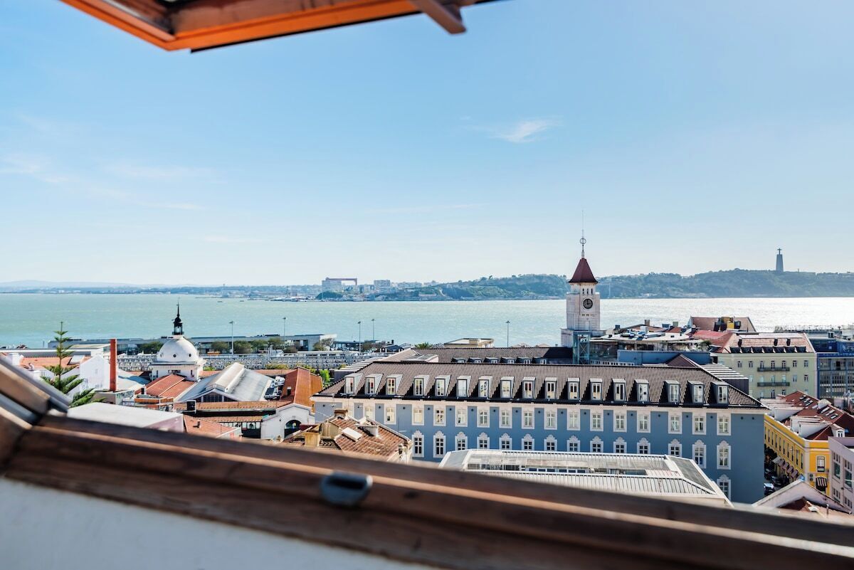 Paisagem costeira com edifícios históricos, uma torre do relógio imponente e vista para o mar.