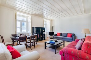 Ein Wohnzimmer mit Essbereich, einer Couch, einem Couchtisch und einem Bücherregal.