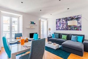 Ein modernes Wohnzimmer mit einer Couch, einem Couchtisch und einem Gemälde an der Wand.
