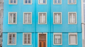 Un edificio de varios pisos con fachada plana, múltiples ventanas y una entrada central.