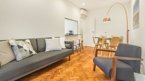 Ein modernes Wohnzimmer mit einer Couch, einem Esstisch und Stühlen.