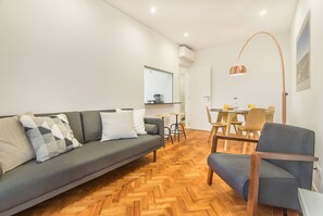 Ein modernes Wohnzimmer mit einer Couch, einem Esstisch und Stühlen.