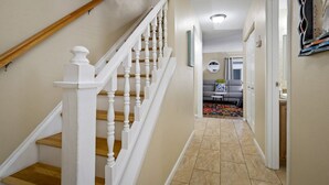 A hallway with a wooden staircase, a sofa, and a small table. - Intracoastal Townhome with Private Entrance, Beach Equipment, and Bikes! (Indian Shores)
