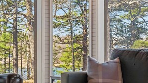 A room with a view of a forest and a body of water. - Little House on Hickory (Lowell)