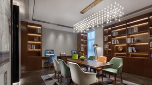 Una sala de reuniones moderna con una mesa grande, sillas cómodas y estanterías empotradas.