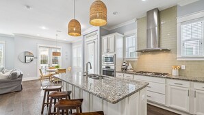 A modern kitchen with white cabinets, a granite countertop, and a stainless steel range hood. - 🌟 *New* Prominence 30A | Heated Pool | Golf Cart | Bikes 🚲 (Inlet Beach)