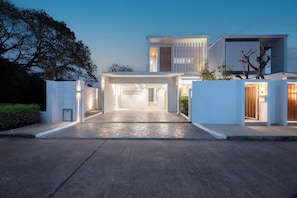 Une maison moderne dotée d’une allée spacieuse et d’une entrée bien éclairée.