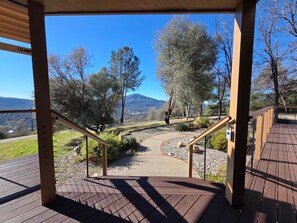 Eine Holztreppe führt zu einer Aussichtsplattform mit freiem Blick auf eine Berglandschaft.