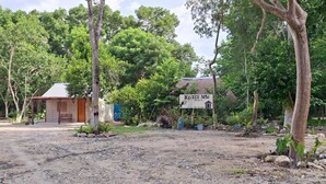 A rural setting with a small building labeled "KOTEN NAG" and a sign indicating a restaurant. - Koten Naj (Calakmul)