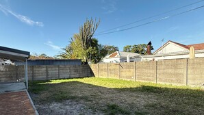 A backyard with a brick patio, a concrete wall, and a grassy area. - Rihla Residences - Civic Road

Fabulous 4-bedroom house in Cape Town (Cape Town)