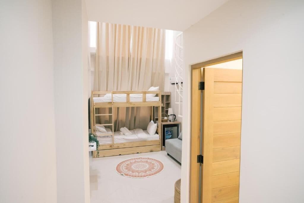 Una habitación pequeña con literas, un escritorio y una silla.