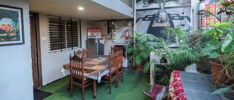 A dining area with a table and chairs, a 'No Smoking' sign, and potted plants.