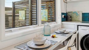 Una cocina con comedor, un mapa en la pared y una lavadora.