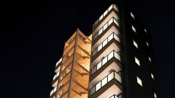 A multi-story hotel with a modern design, featuring balconies, a staircase, and a gated entrance. - SDC Namba (Osaka)