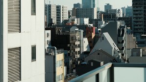 A cityscape with a prominent modern skyscraper in the background, surrounded by various buildings. - SDC Namba (Osaka)