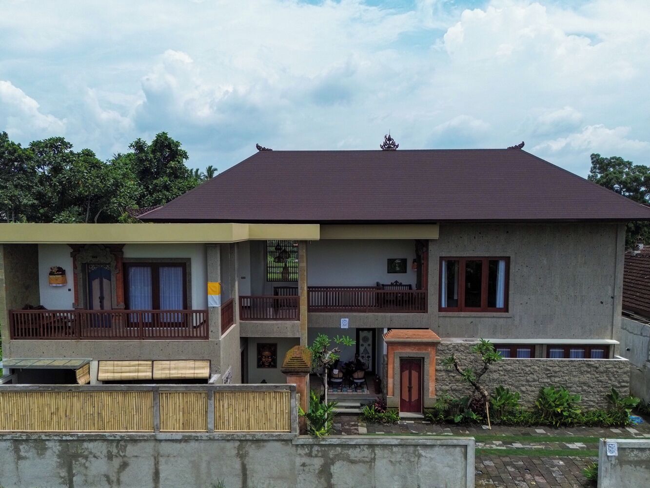 Un bâtiment à deux étages, doté d’un toit plat, d’un balcon à l’étage supérieur et d’une petite entrée avec une porte.