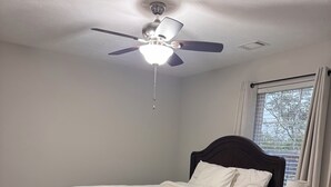 A bedroom with a bed, a ceiling fan, a window with curtains, and a small table with a lamp. - Private Room & Bath in Augusta (Augusta)