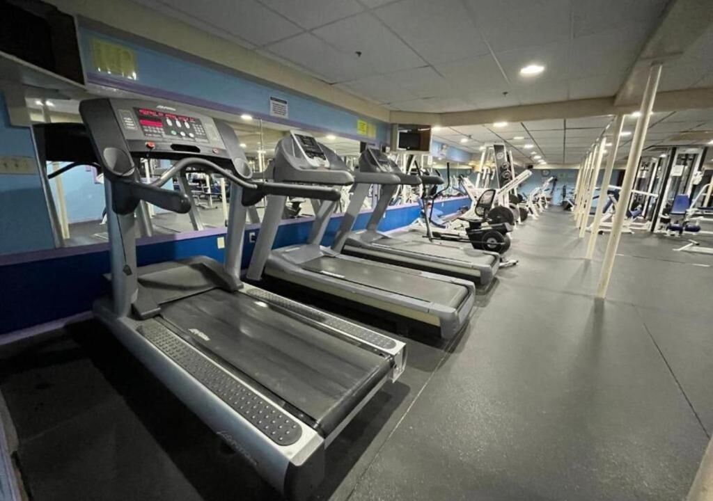 Et fitnesscenter med flere løbebånd og træningsmaskiner.