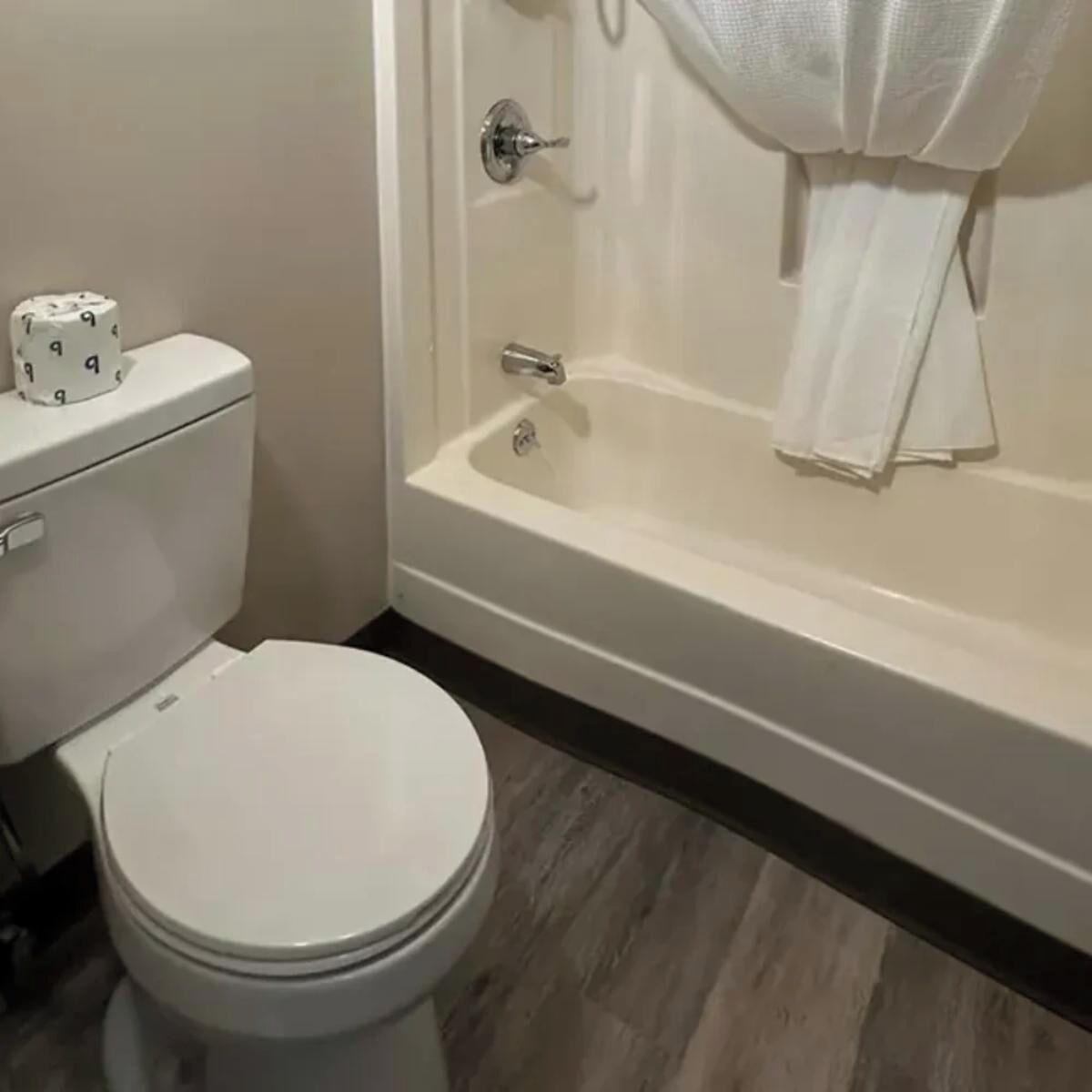 A bathroom with a toilet, a bathtub, and a shower.
