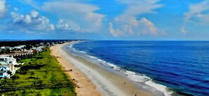 Ein Küstenblick mit Strand, Meer und Wohngebiet.