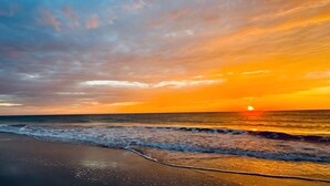 Una spiaggia con onde e un tramonto.
