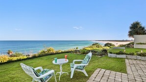 A patio with two chairs and a table overlooking a beach. - Seaspray Unit 2, 21 Warne Tce, Kings Beach (Kings Beach)